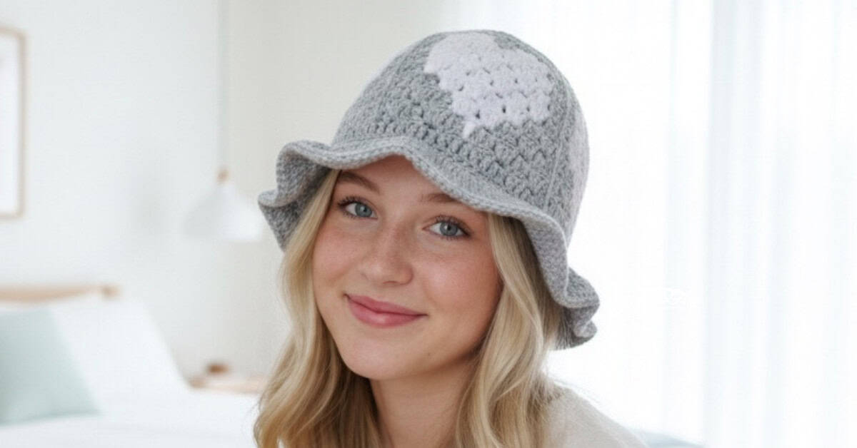 Teen girl wearing a gray crochet bucket hat with white heart motifs in a bright modern bedroom.