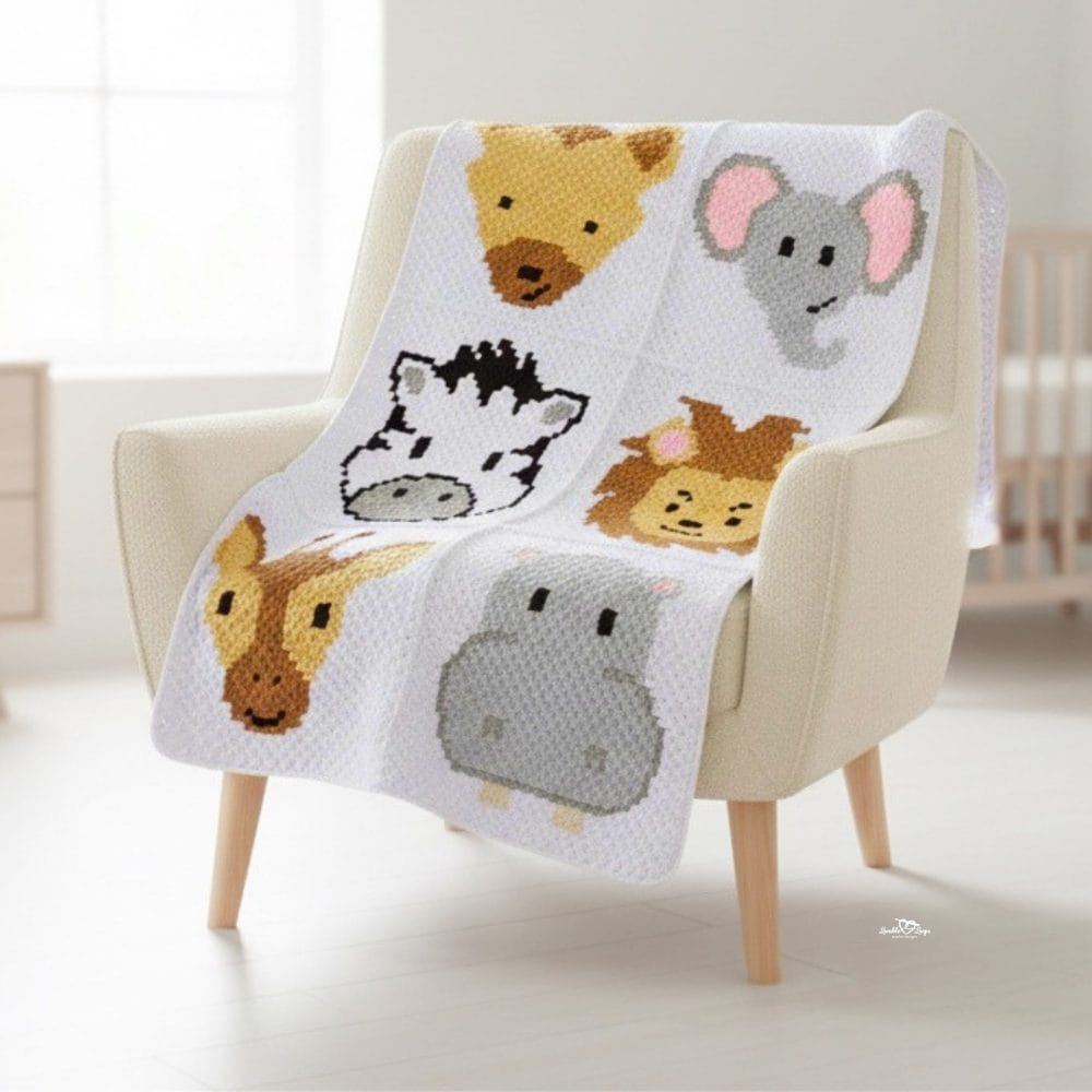 Safari animal crochet baby blanket draped over a cream armchair in a bright nursery, featuring cute animal blocks with a giraffe, elephant, zebra, lion, buffalo, and hippo.