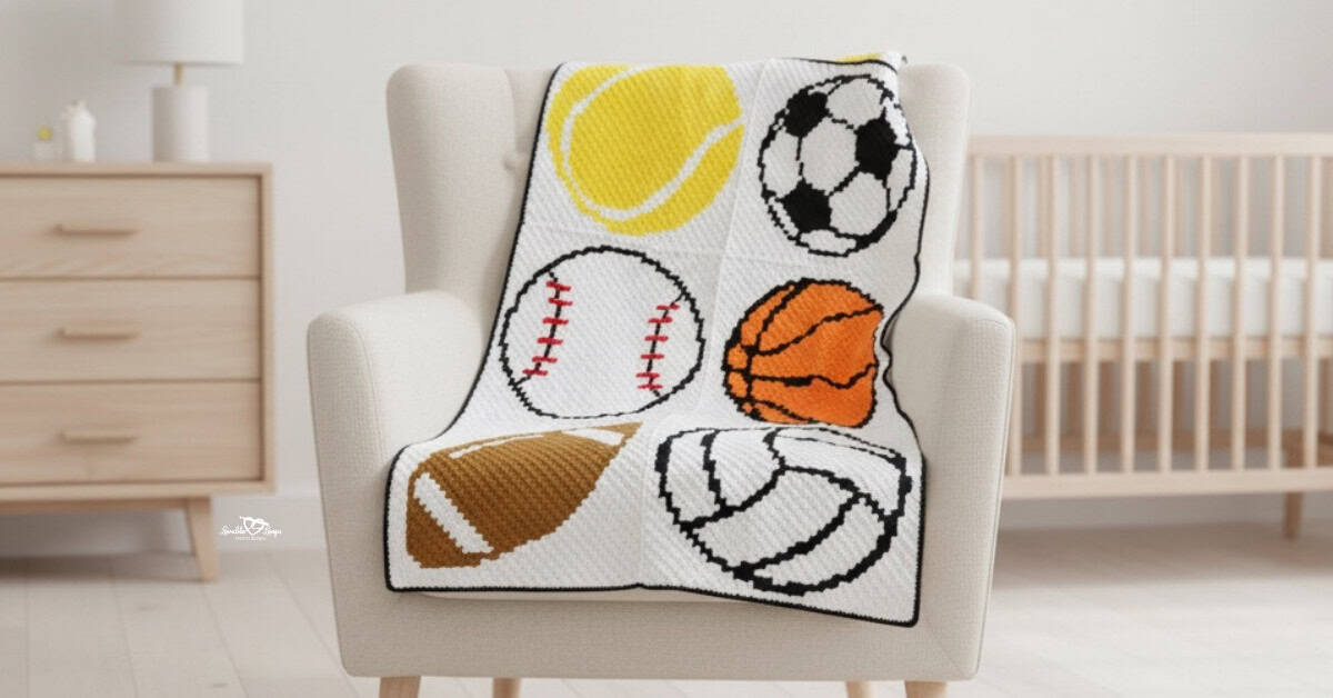 C2C sports crochet baby blanket with a tennis ball, soccer ball, baseball, basketball, football, and volleyball draped over a cream armchair in a bright nursery.