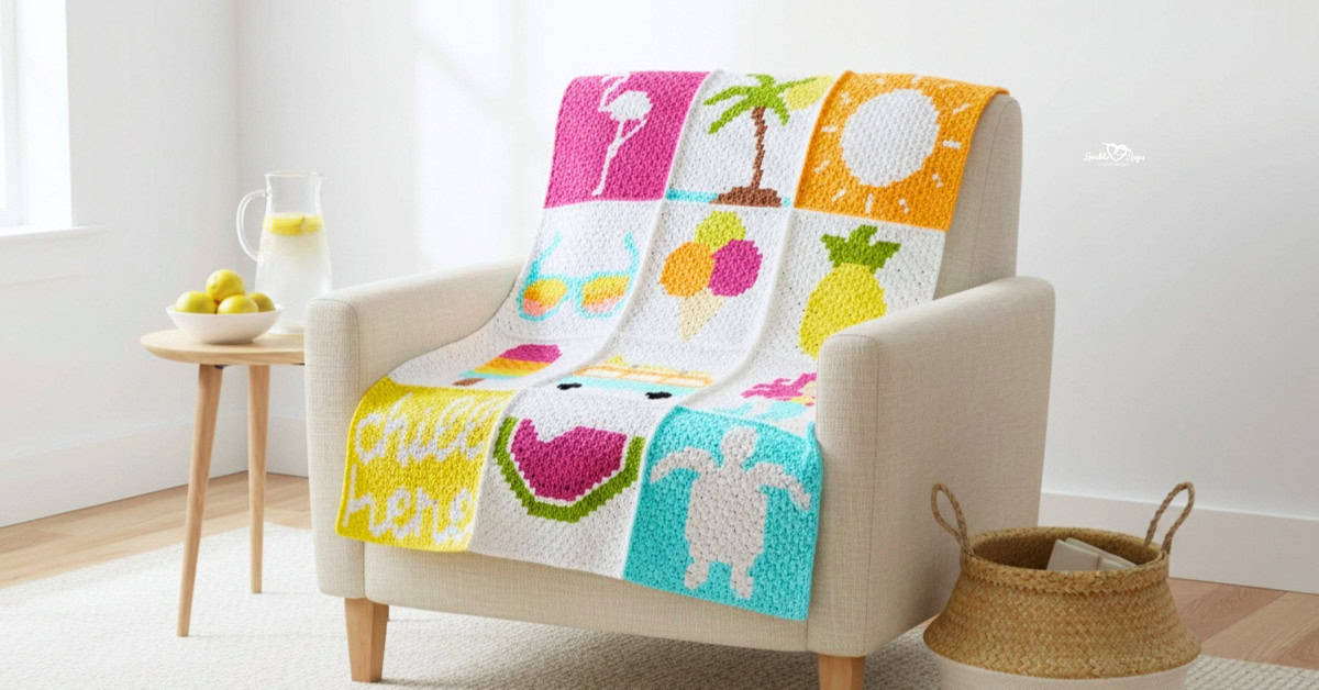 C2C summer blanket draped over a cream armchair in a bright living room, featuring colorful seasonal squares like a flamingo float, palm tree, sunshine, lemonade, fruit, watermelon, and sea turtle, with lemons and lemonade on a side table.