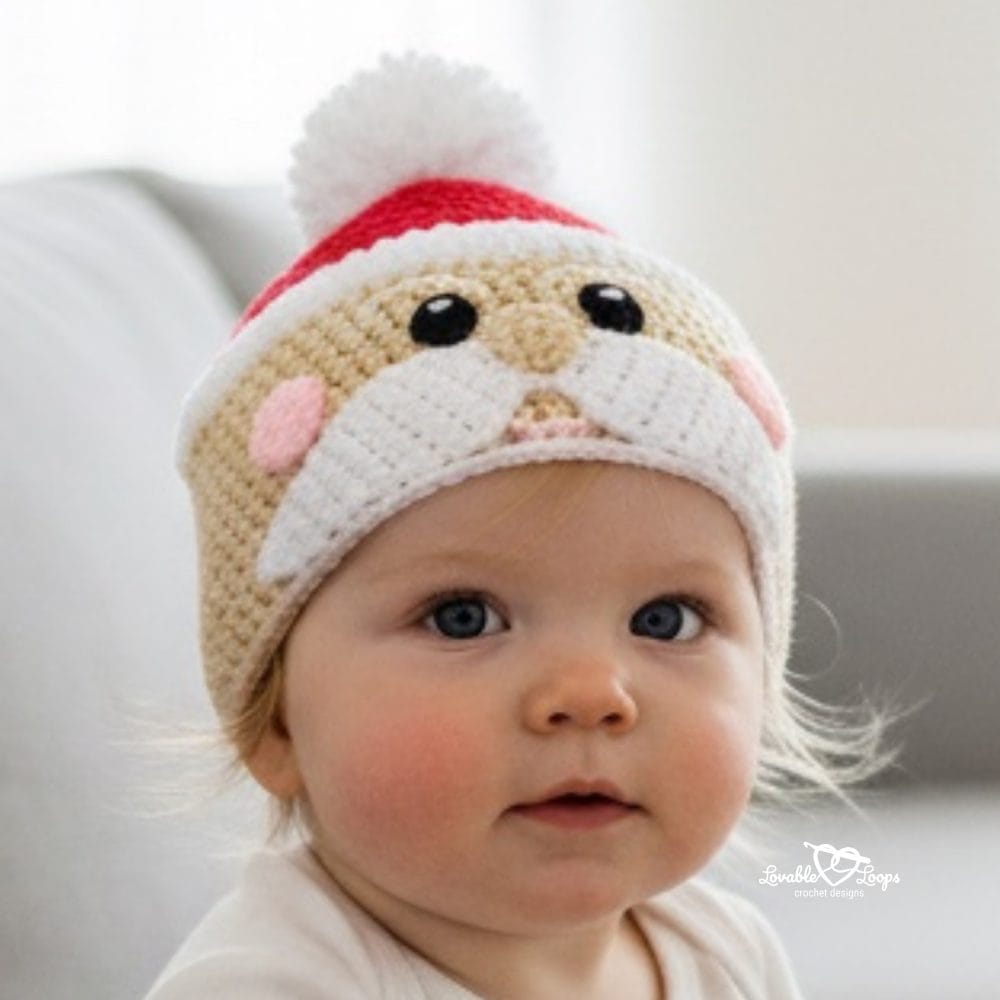 Baby wearing a crochet Santa face hat with rosy cheeks, a white mustache, and a fluffy white pom-pom.