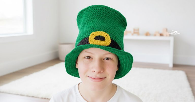 Boy wearing a tall green crochet leprechaun top hat with a black band and gold buckle in a bright modern boys’ room.