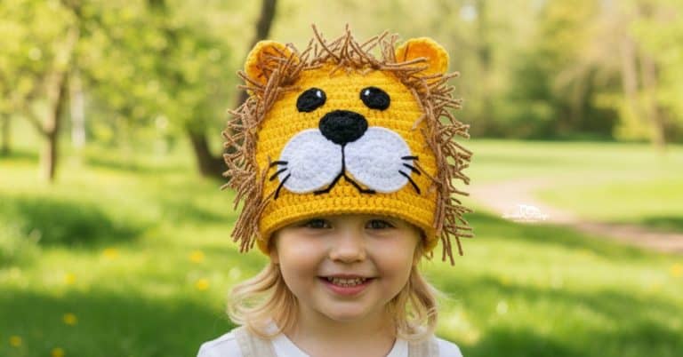 Child wearing a crochet lion hat with a yarn mane on a sunny green nature trail with trees in the background