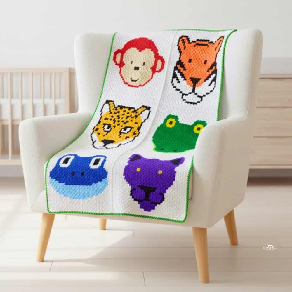 C2C jungle animal crochet blanket draped over a cream armchair, featuring colorful animal faces in six blocks.