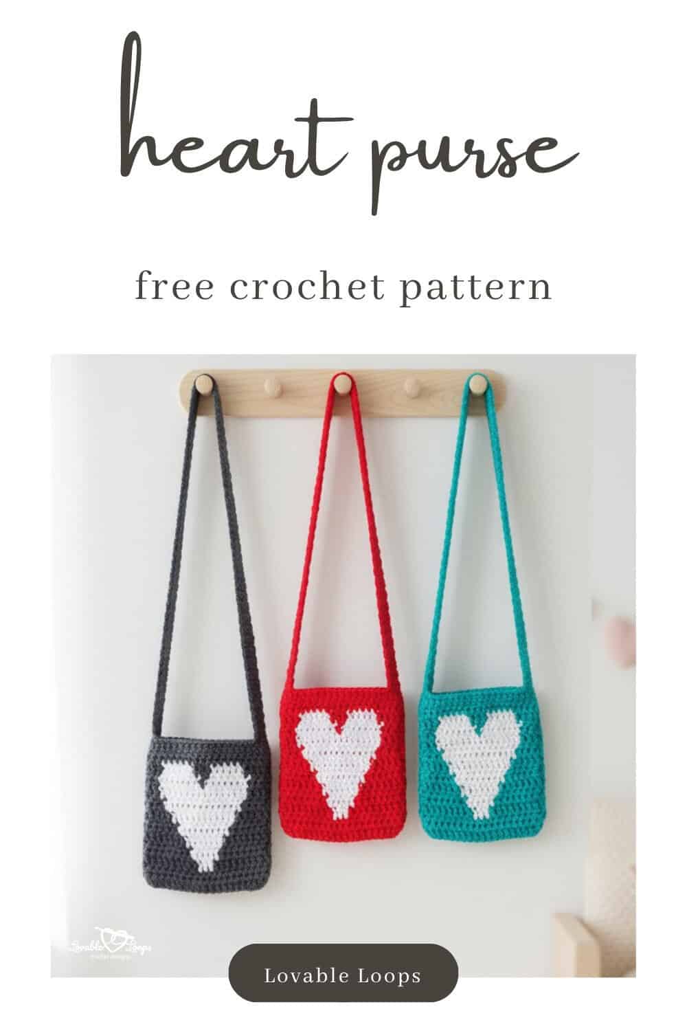 Three small crochet heart purses hanging from a wooden peg rack on a white wall, shown in dark gray, red, and teal with white heart designs on the front.