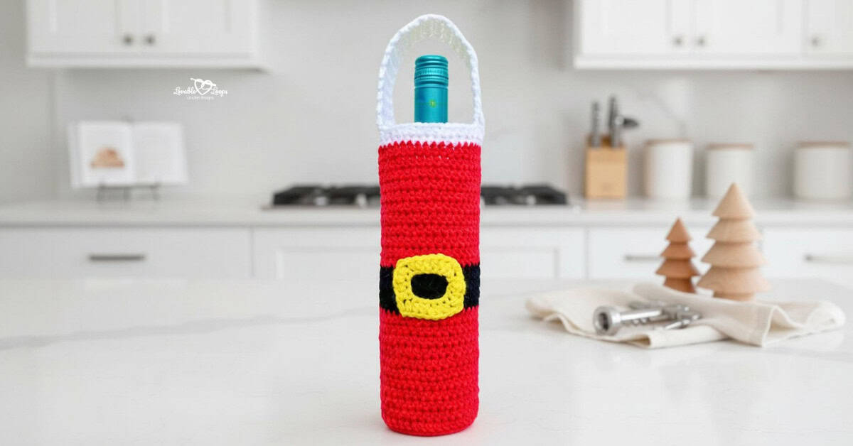 Red and white crochet Santa wine bottle bag displayed on a bright kitchen island with minimal Christmas decor in a modern white kitchen.