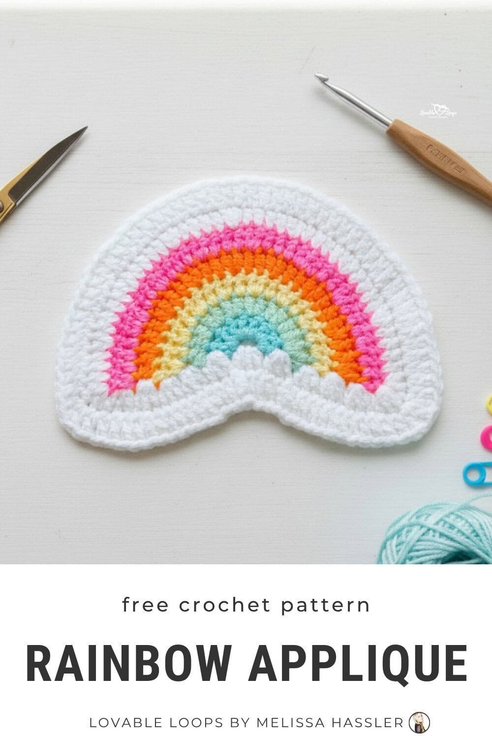 Crochet rainbow applique pattern in pastel colors on a white desktop with scissors and a crochet hook nearby.