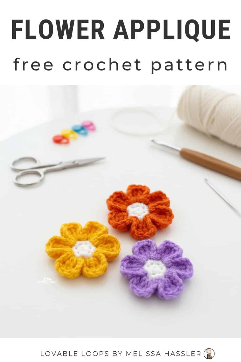 Flower applique crochet pattern displayed on a bright white desktop with three colorful crochet flowers and simple craft tools around them.