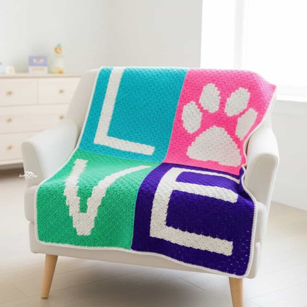 crochet love paw print blanket pattern featuring a bright four-panel C2C blanket with &ldquo;LOVE&rdquo; letters and a paw print design